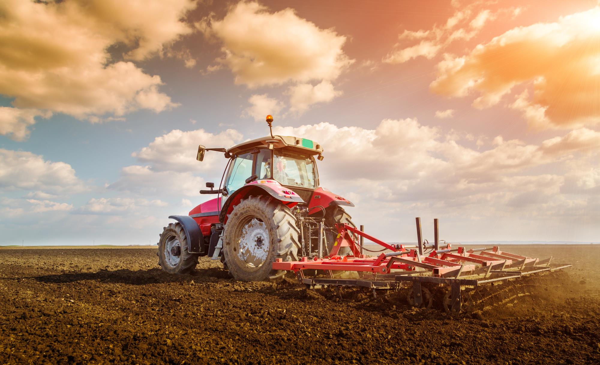 tractor in field sunset